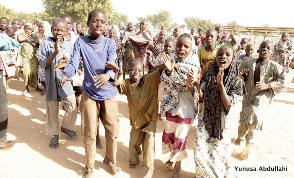 Excited campers jubilate with the arrival of trucks with food items and other materials