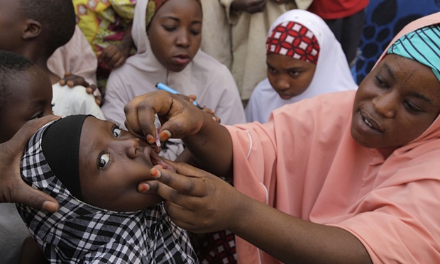 A woman administering a vaccine to a child