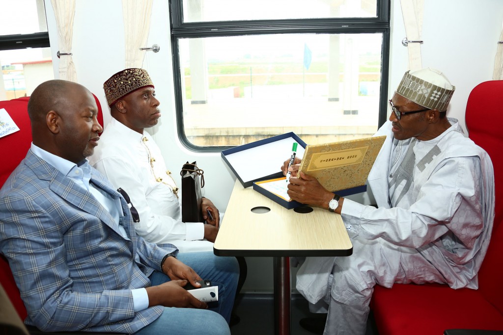 President Muhammadu Buhari signing document on the train. With him are Minister of Transportation, Mr Rotimi Amaechi and Minister of State Aviation, Senator Hadi Sirka as President Commission/Flag-off Abuja-Kaduna Commercial Operation Rail Station at IDU Station in Abuja. 