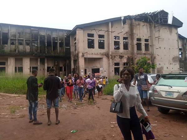 Students coming out of a bushy, abandoned building used as exam hall IMSU, one of the public universities in Nigeria