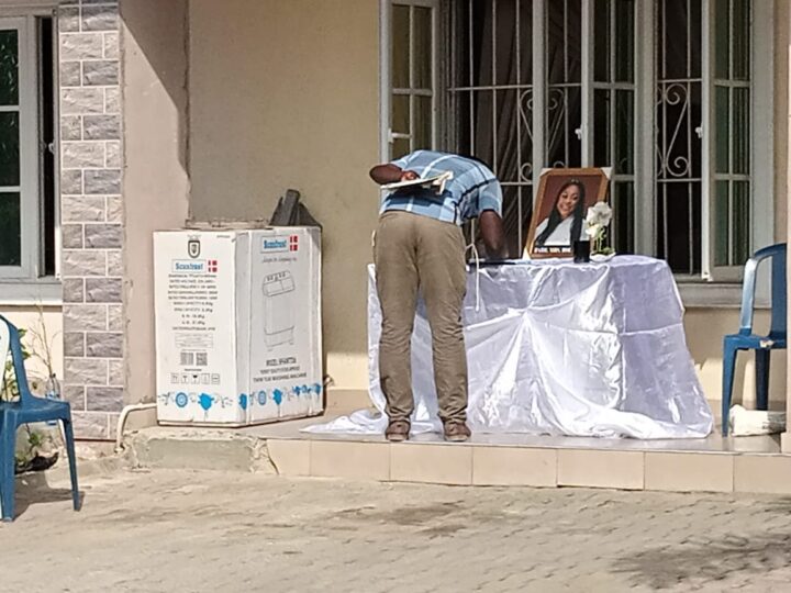 A man signing condolence register for Bolanle Raheem