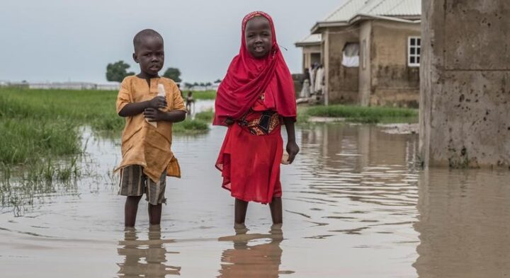 children standing in a flooded area in Nigeria