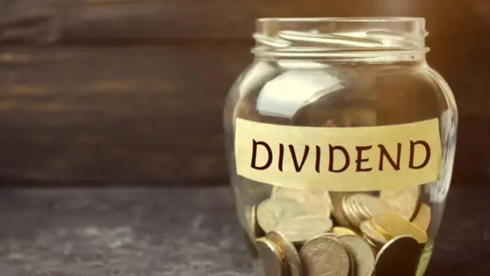 A jar filled with coins labelled dividends