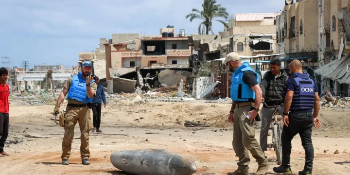 A UN team inspects an unexploded 1,000-pound bomb lying on a main road in Khan Younis. Photo credit: OCHA