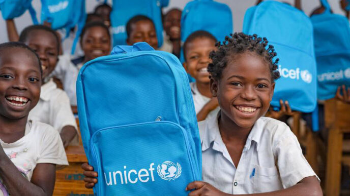 An illustrative image of school children holding up UNICEF backpacks.