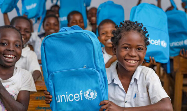 An illustrative image of school children holding up UNICEF backpacks.