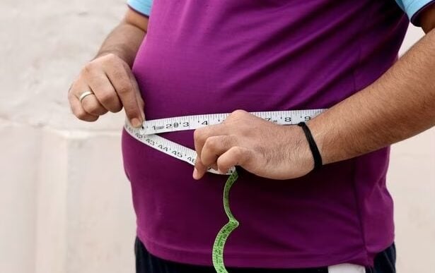 A man measuring his protruding belly