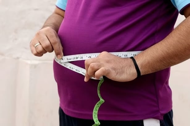 A man measuring his protruding belly