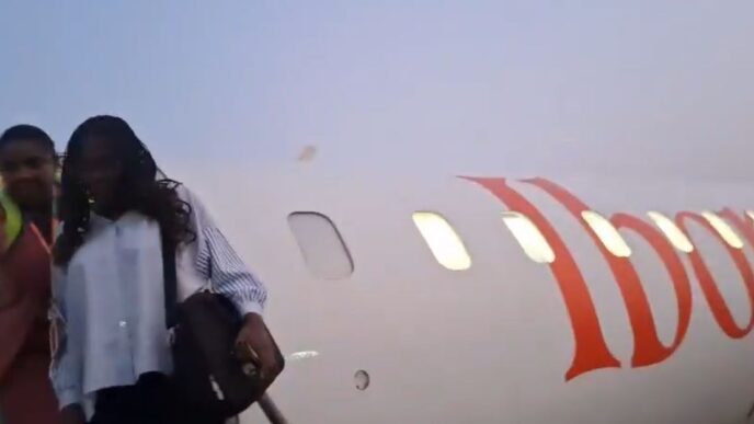 An airport official escorting the passenger out of the aircraft in Uyo