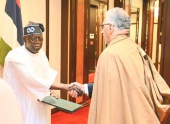 Tinubu (left) is received by an Ethiopian government official on arrival in Addis Ababa